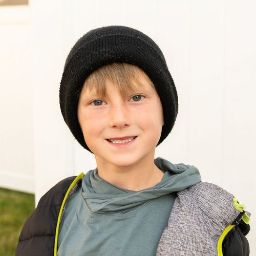 A child wearing a winter hat and smiling