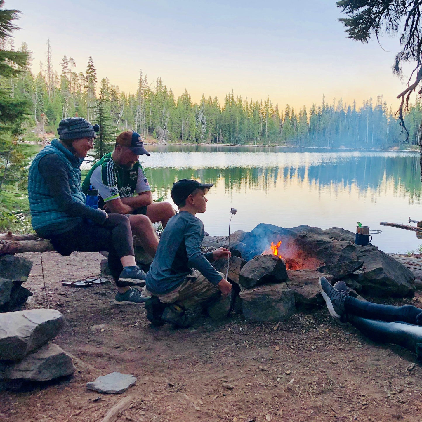 family camping and roasting marshmallows on a fire