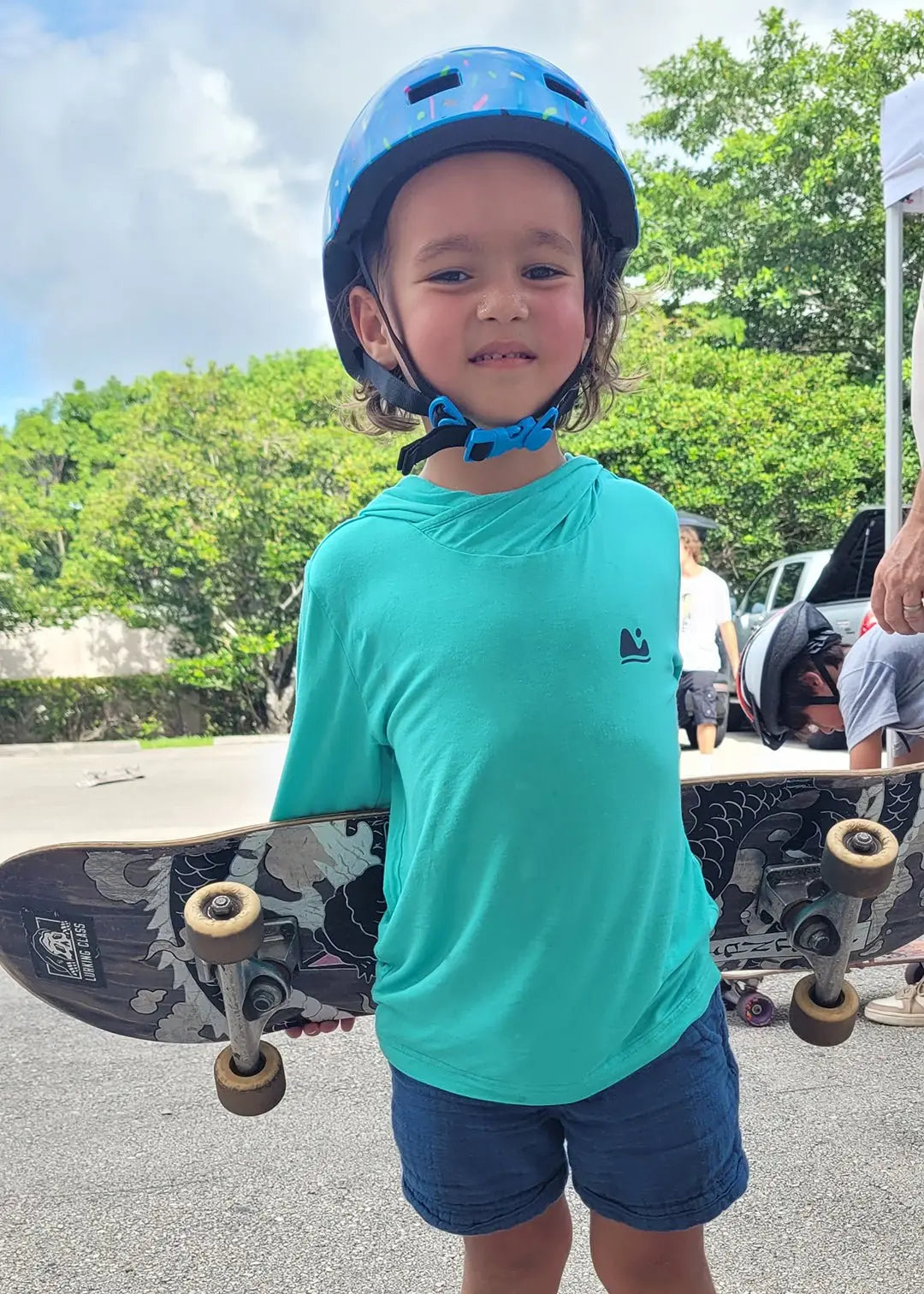 boy skating with his bamboo sun shirt for kids by play outside