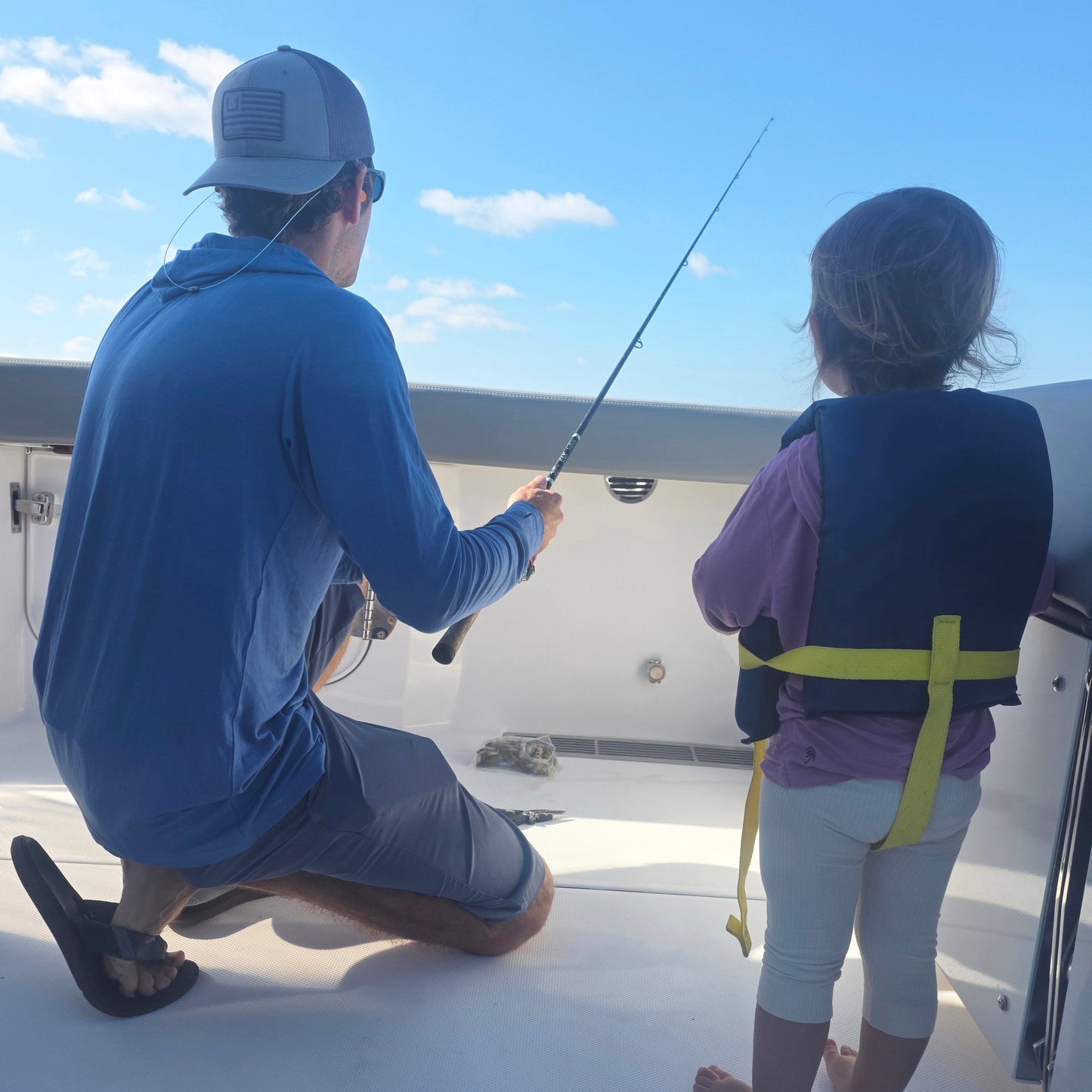 dad and daughter fishing on boat