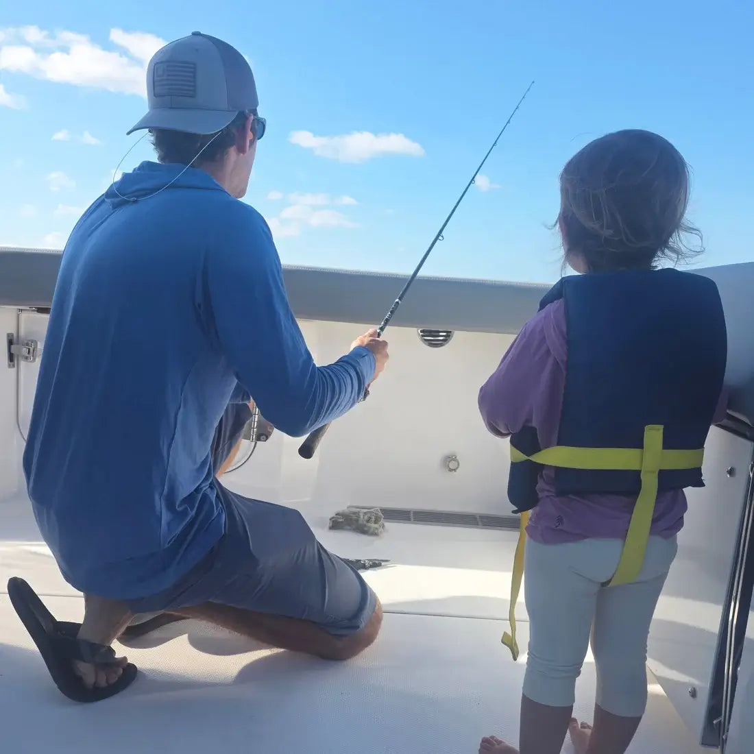 dad and daughter fishing on boat