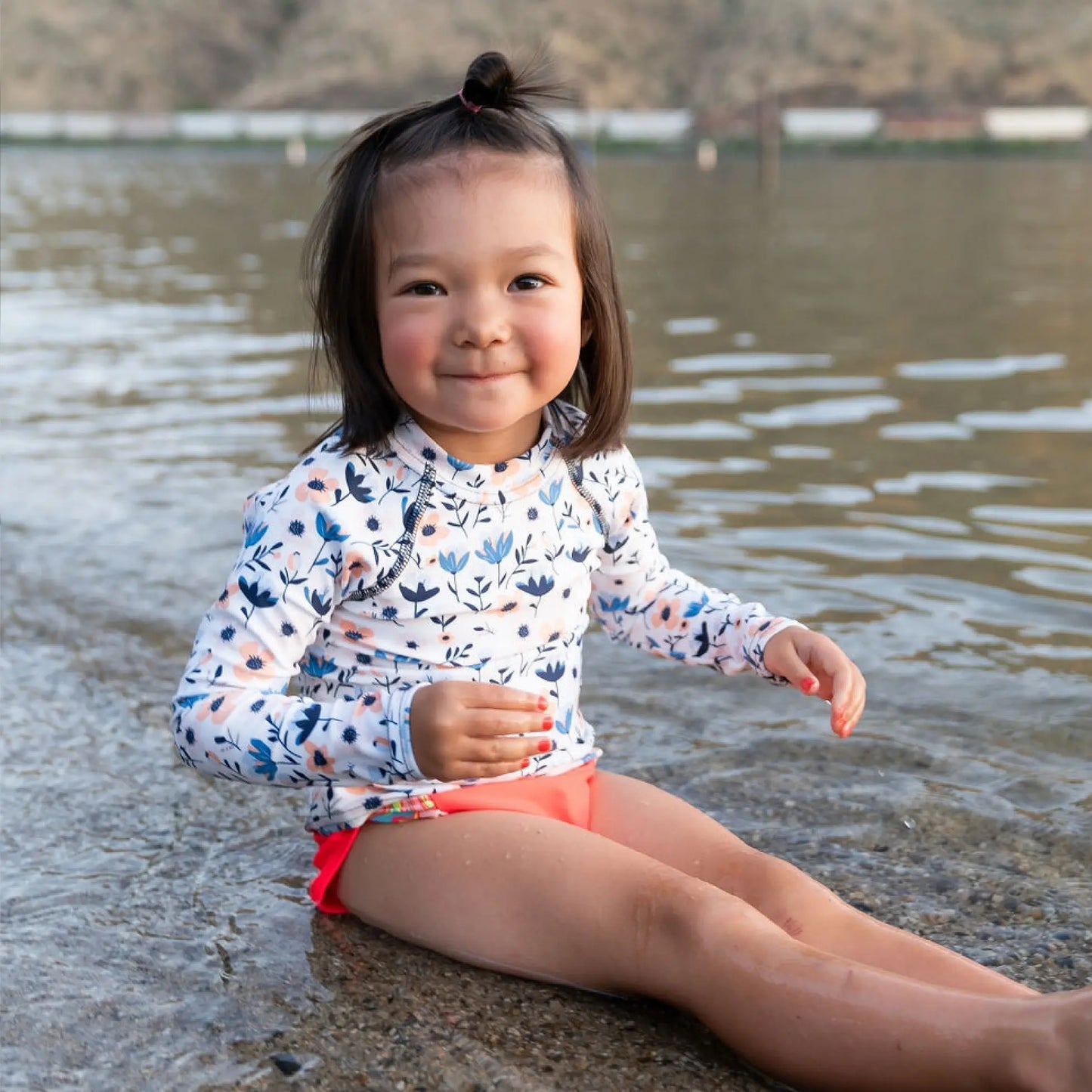 A happy girl splashing in a lake, showcasing the joy and mental health benefits of nature.