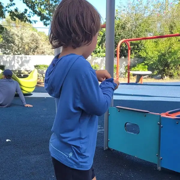 boy wearing blue sun shirt at the park
