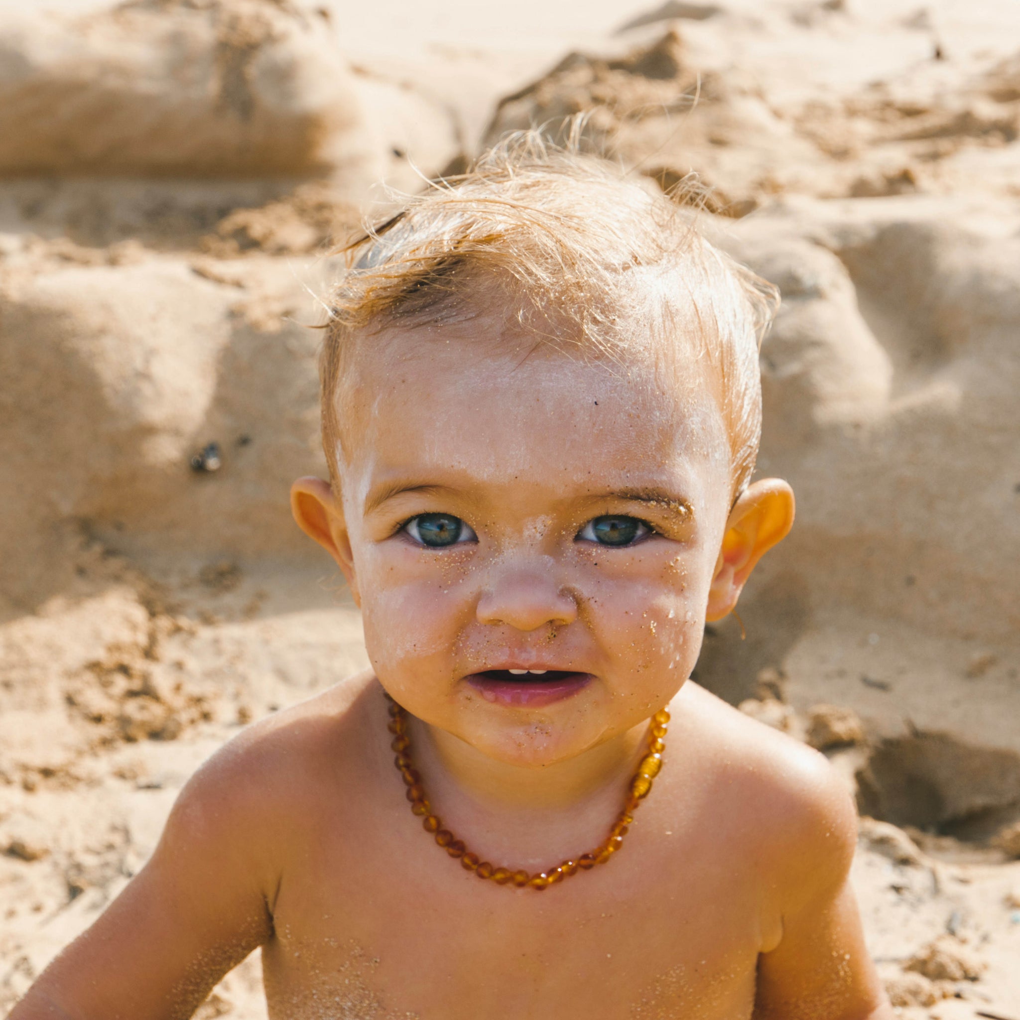 baby at the beach with sunscreen on his face