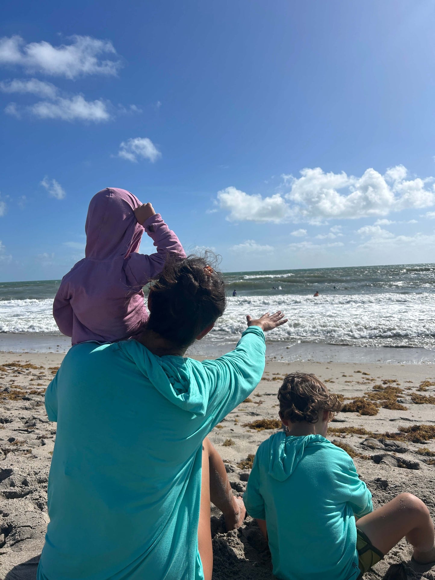 family at the beach wearing sun shirts