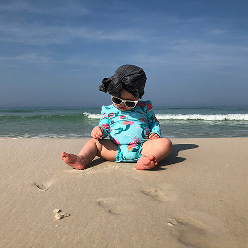 baby with full cover bathing suit at the beach