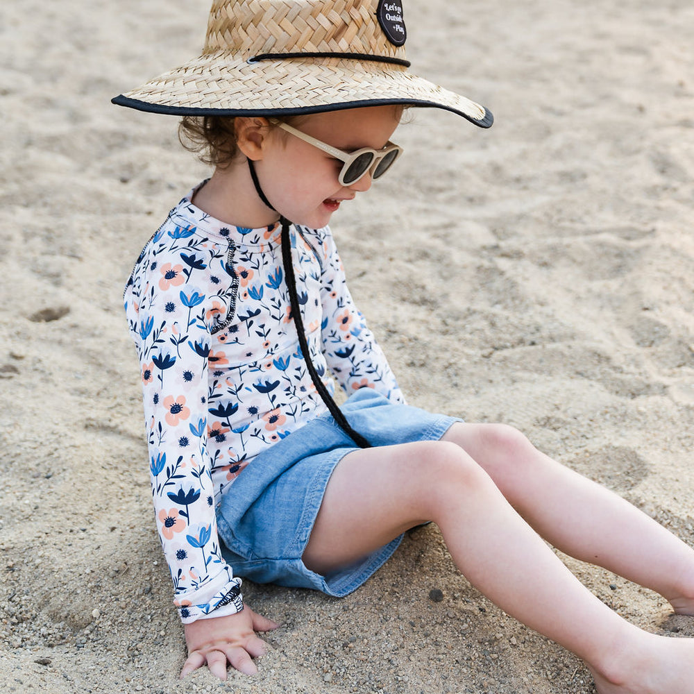 
                      
                        Little girl wearing the Play Outside Kids Beach Comber Straw Hat at the beach, featuring a wide brim for sun protection and breathable natural straw design.
                      
                    