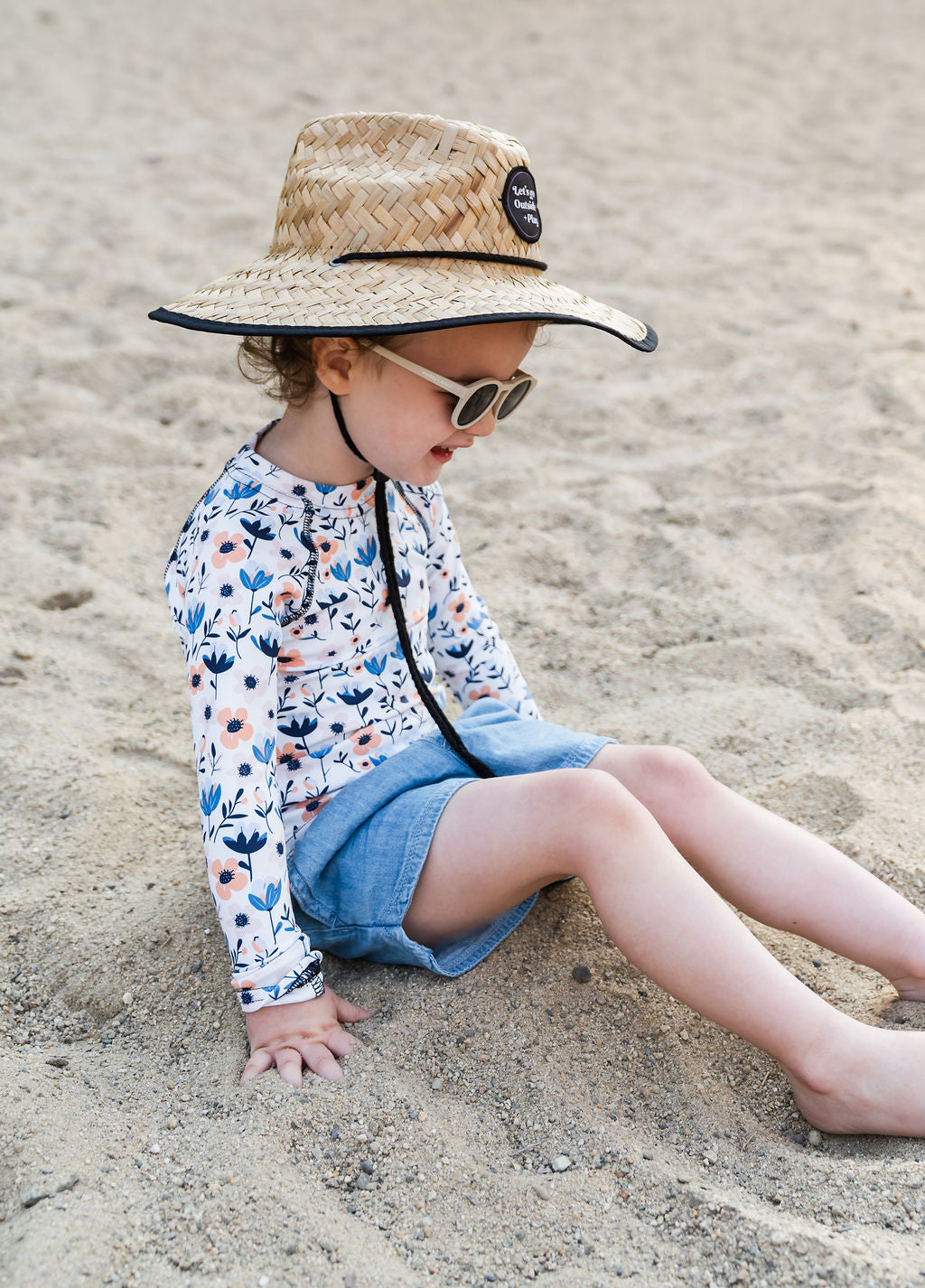 Little girl wearing the Play Outside Kids Beach Comber Straw Hat at the beach, featuring a wide brim for sun protection and breathable natural straw design.