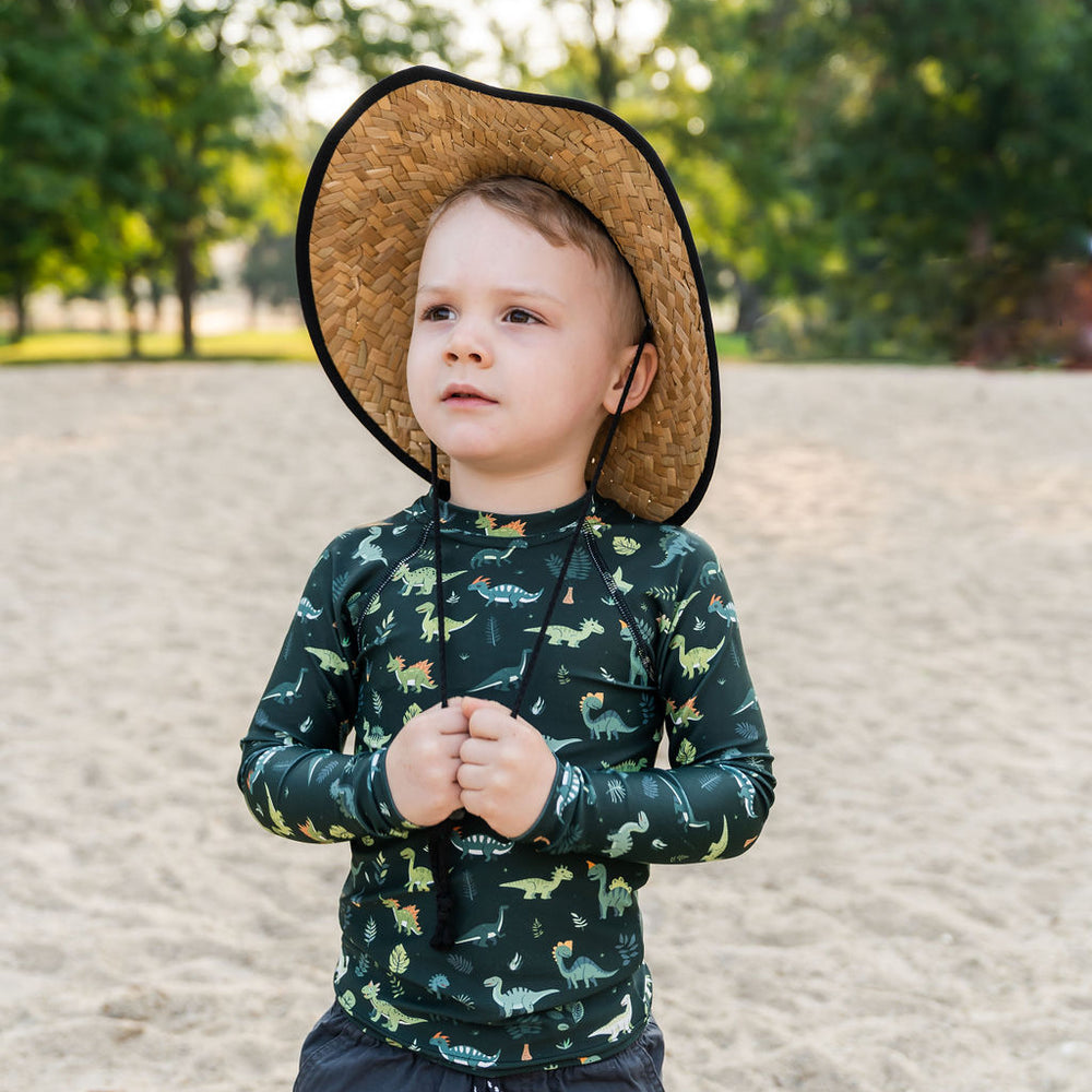 
                      
                        Little boy wearing Muddy + Mind’s Kids Beach Comber Straw Hat and UPF 50+ rash guard, staying sun-safe during a beach adventure.
                      
                    