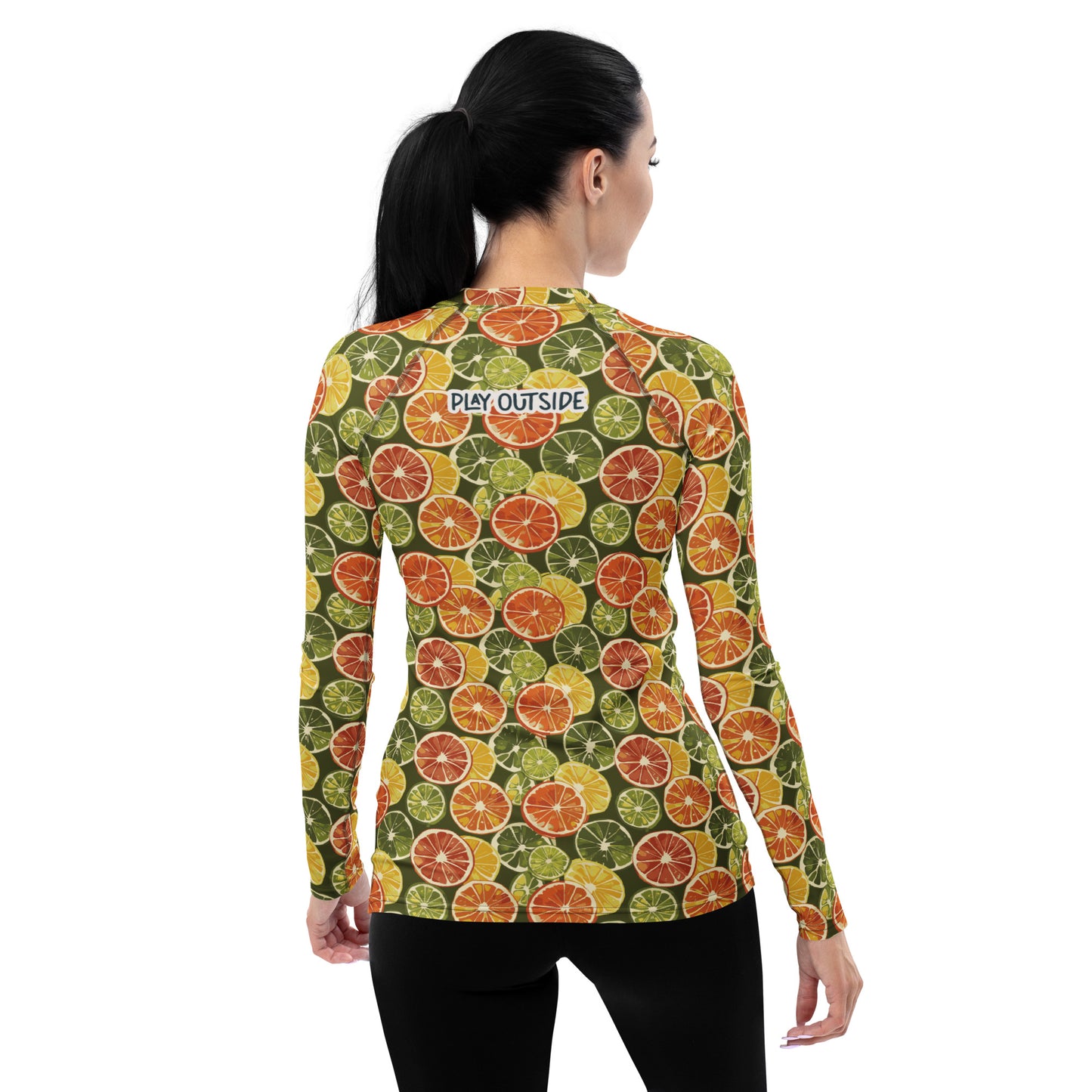A women’s rash guard showcasing a cheerful citrus design with orange and green hues, displayed from the back.