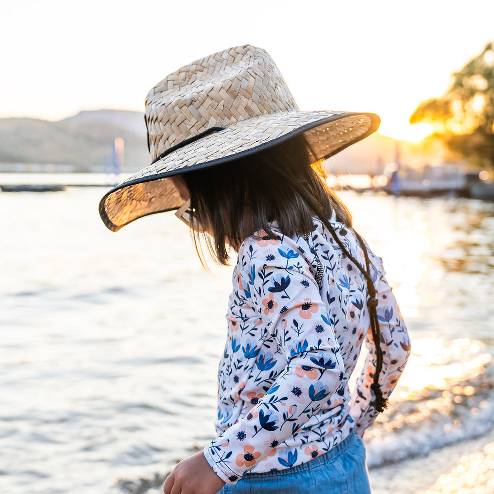 
                      
                        Girl enjoying outdoor play in Muddy + Mind’s straw hat and protective rash guard, offering all-day sun protection and comfort.
                      
                    
