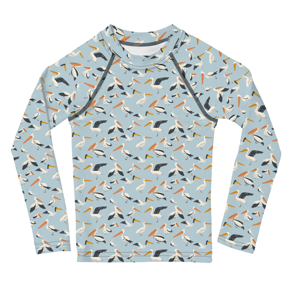 A kids' rash guard with a fun pelican pattern in blue and white, ideal for beach days, displayed from the front.