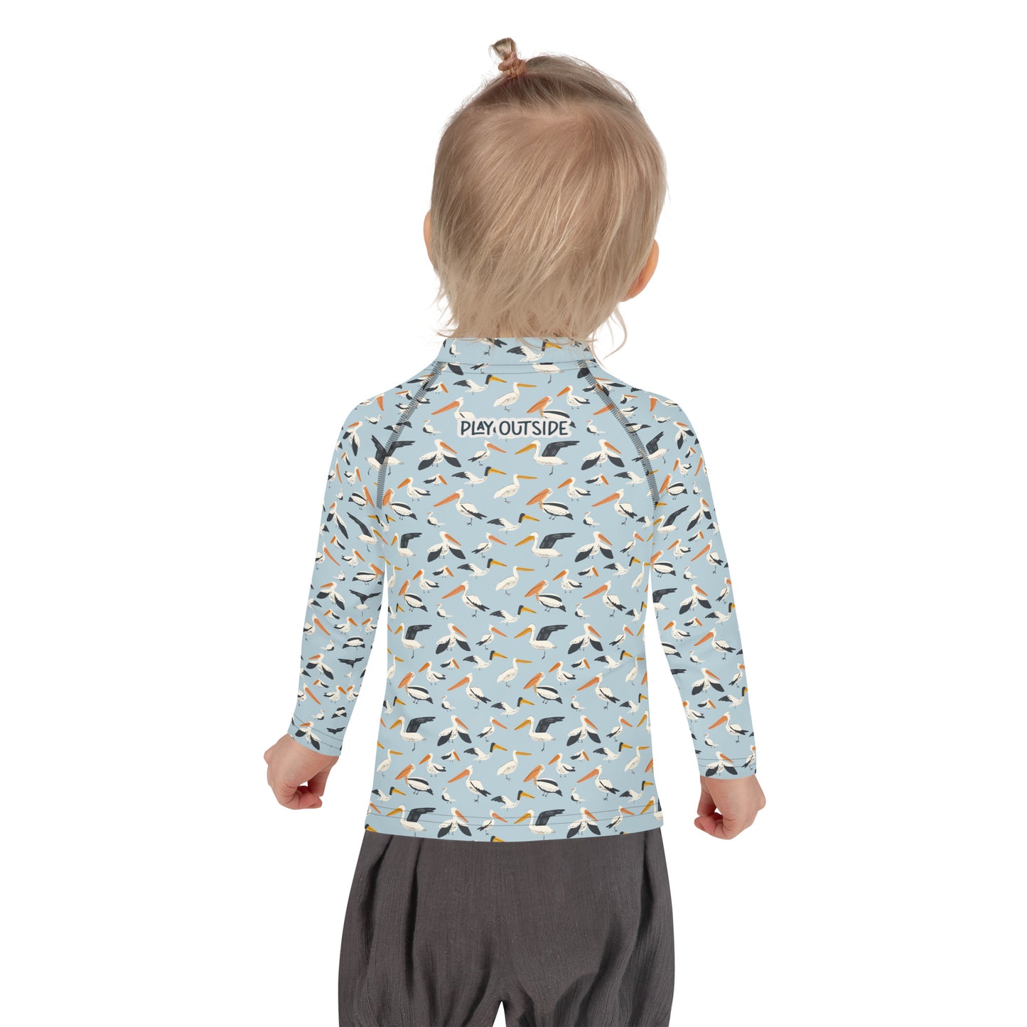 A child wearing a pelican-themed rash guard, showcasing the playful bird design from the back.