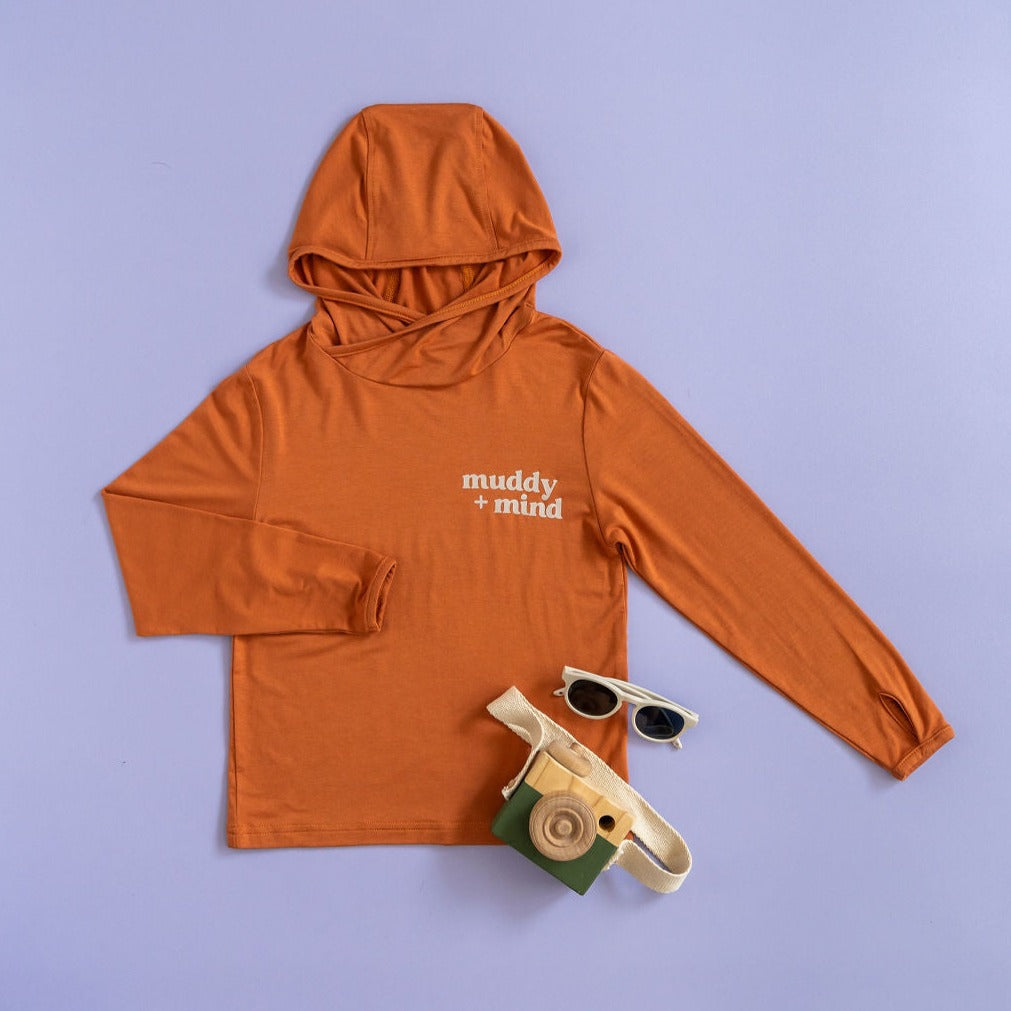 The ONE Shirt by Muddy + Mind in Terracotta, a bamboo-blend all-weather shirt for toddlers and kids with UPF 50+ sun protection.