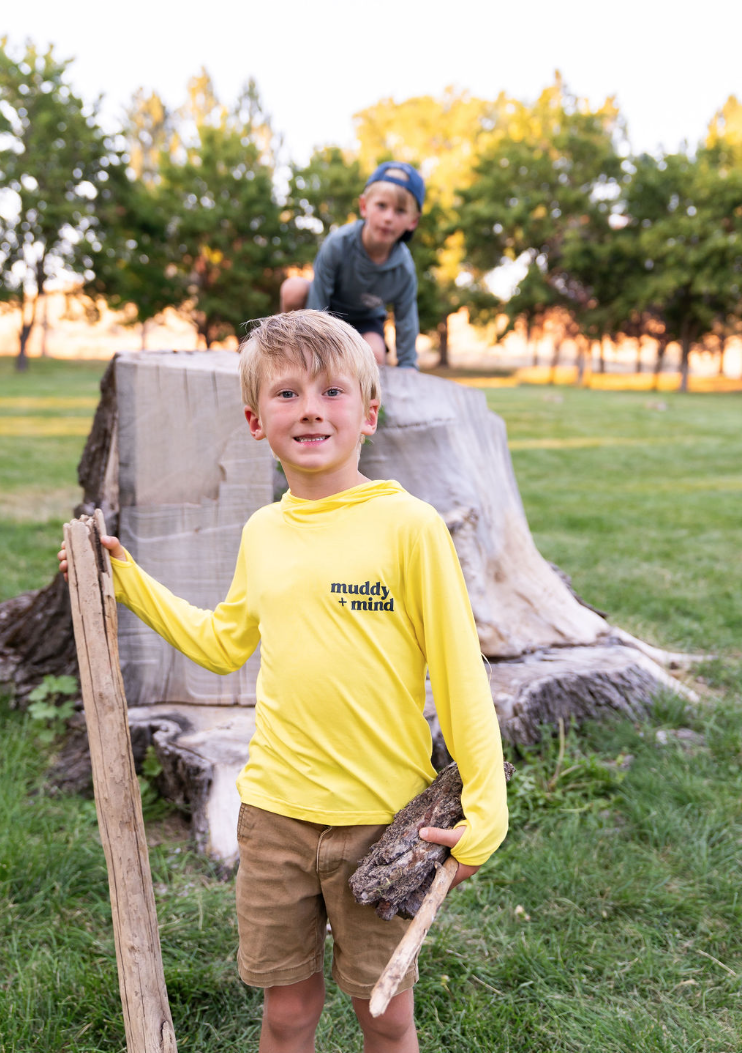 Child enjoying outdoor play in The ONE Shirt, offering versatile sun-safe protection and comfort for all-day adventures.