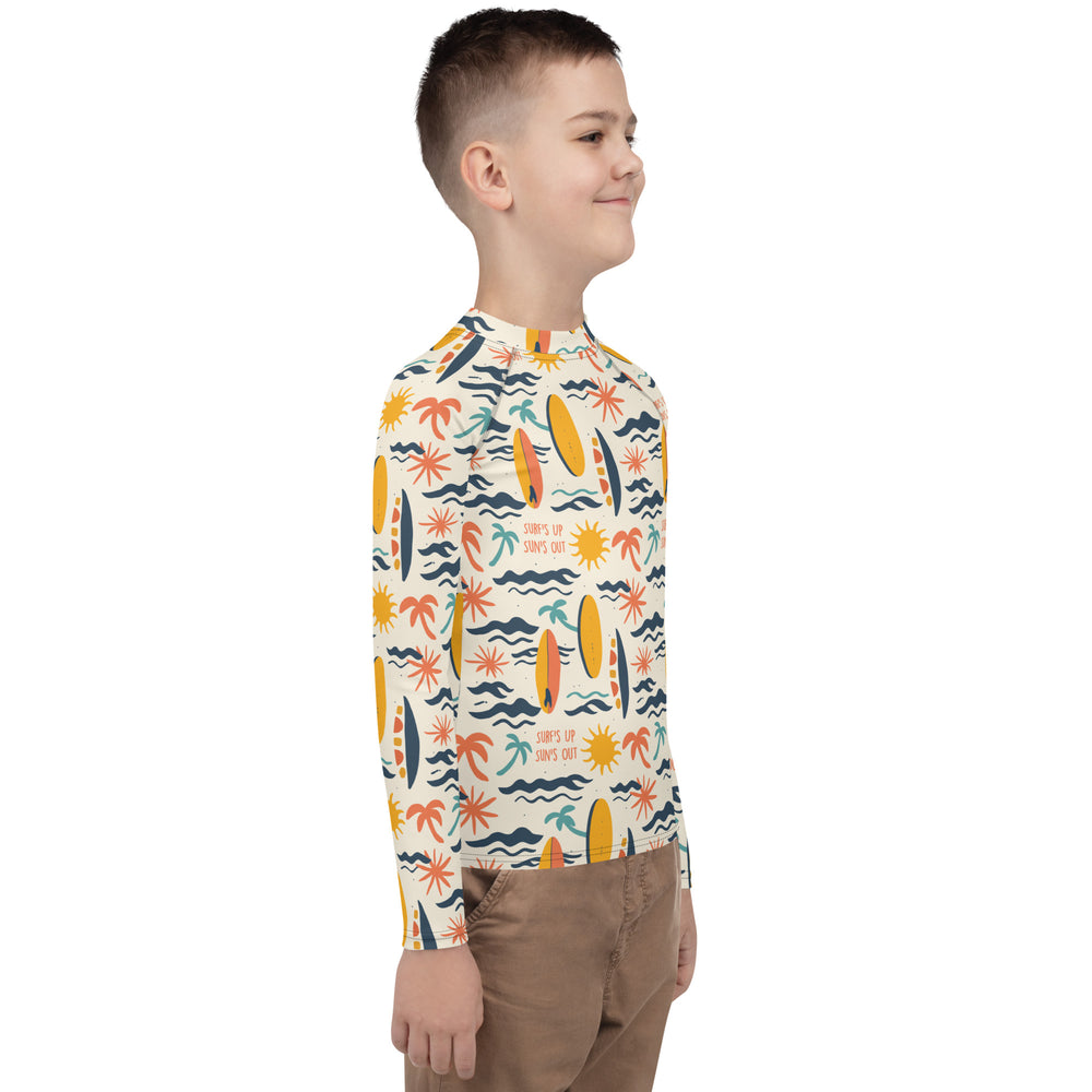 A surf-themed rash guard for youth with wave patterns, crafted for durability, sun protection, and outdoor fun.