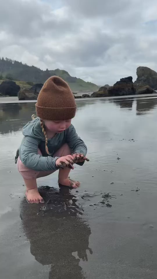 toddler girl playing with her bamboo sun shirt by play outside